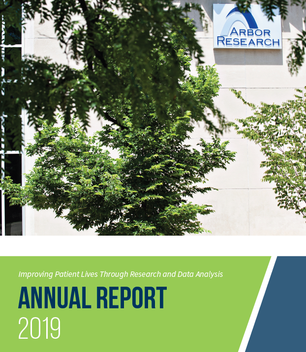 2019 Report Annual Cover. The top half shows a photo of green trees with a beige exterior wall in the background. Below that, a wide green stripe contains the report title text.